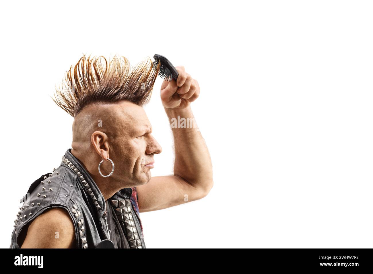 Punk mit einem mohawk, der sein Haar isoliert auf weißem Hintergrund kämmt Stockfoto