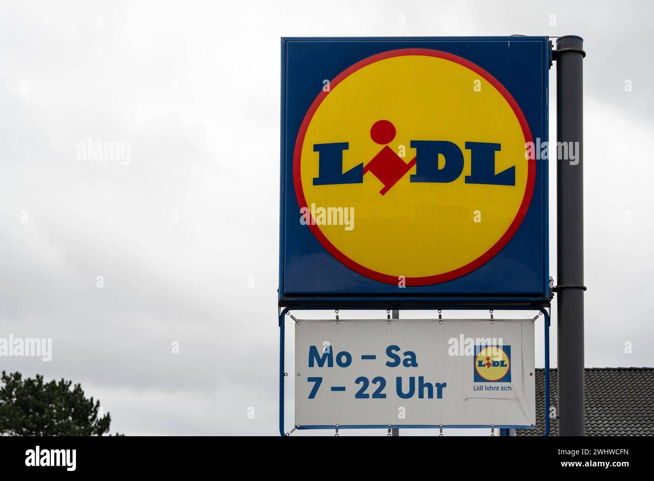 Lidl Werbeschild mit Öffnungszeiten 10.02.24, Diez: Symbolfoto, Illustrationsbild, Symbolbild, Illustrationsfoto Lidl Werbeschild mit Öffnungszeiten Neben dem auffälligen Werbeschild von Lidl, das im Vordergrund steht und auf aktuelle Angebote des Discounters hinweist, ist ein Zusatzschild mit den Öffnungszeiten des Geschäfts zu sehen. Das Öffnungszeitenschild informiert darüber, dass Lidl von Montag bis Samstag, von 07:00 bis 22:00 Uhr geöffnet ist. Obwohl das Geschäft selbst nicht im Bild erscheint, vermittelt die Kombination der Schilder wichtige Informationen für die Kunden und betont die Stockfoto