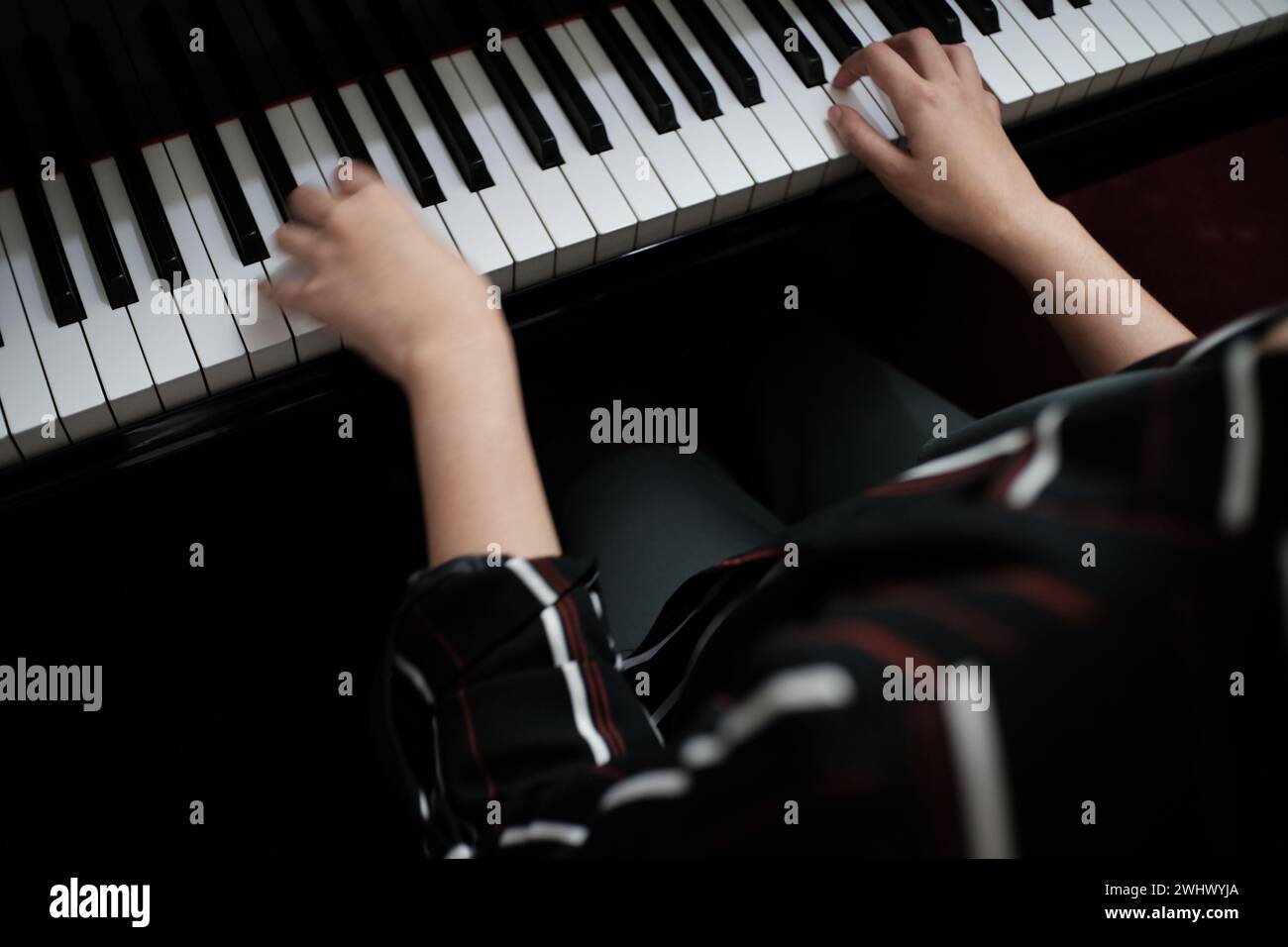 Schöne asiatische Mädchen lernen Klavier zu spielen. Stockfoto
