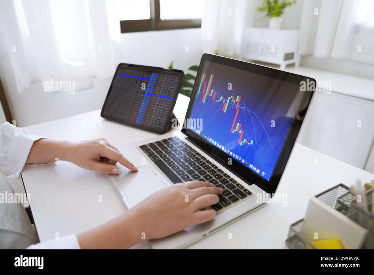 Anleger, die Kryptowährungen online handeln, arbeiten zu Hause. Chart geeignet für Börsenbörsen-Forex- oder Kryptografiehandel Finanzinstrumente Stockfoto