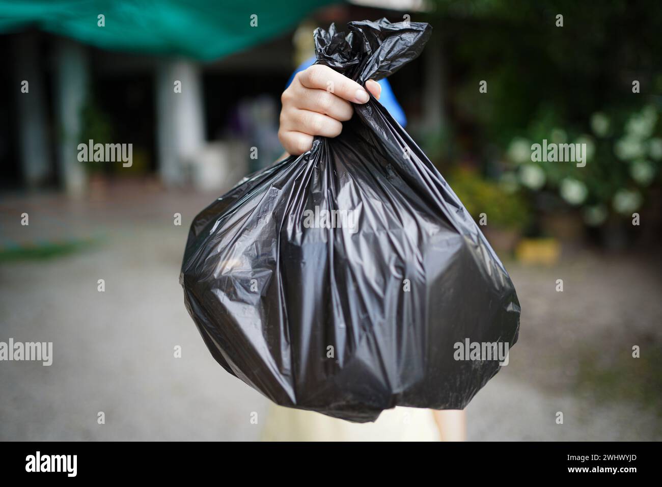 Freiwillige Wohltätigkeitsorganisation womanÂ Hand hält Müllbeutel und Plastikflaschenmüll zum Recycling für die Reinigung im Park Freiwilligendienst Stockfoto