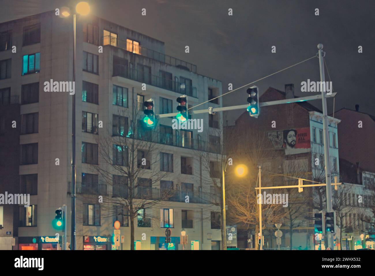 Brüssel, Belgien Februar 2024. Abstrakte Straßenlandschaft. Fassade der Brüsseler Gebäude. Helles künstliches Licht. Ampel im Dunkeln Stockfoto