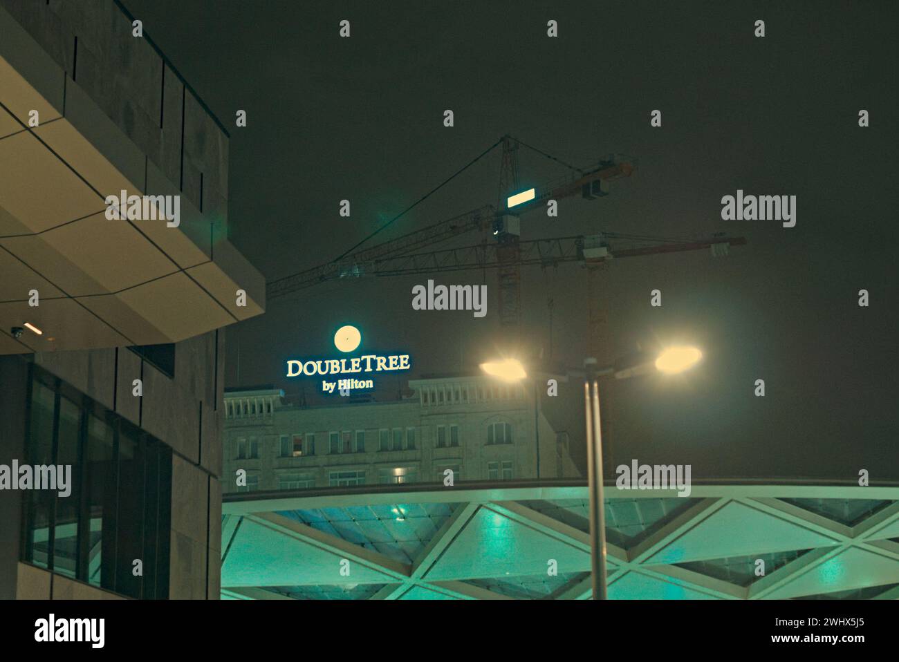Brüssel, Belgien Februar 2024. Teil der Fassade des Double Tree by Hilton Hotels. Ein Blick auf die Stadt bei Nacht. Teil der Fassade des Starbucks Stockfoto