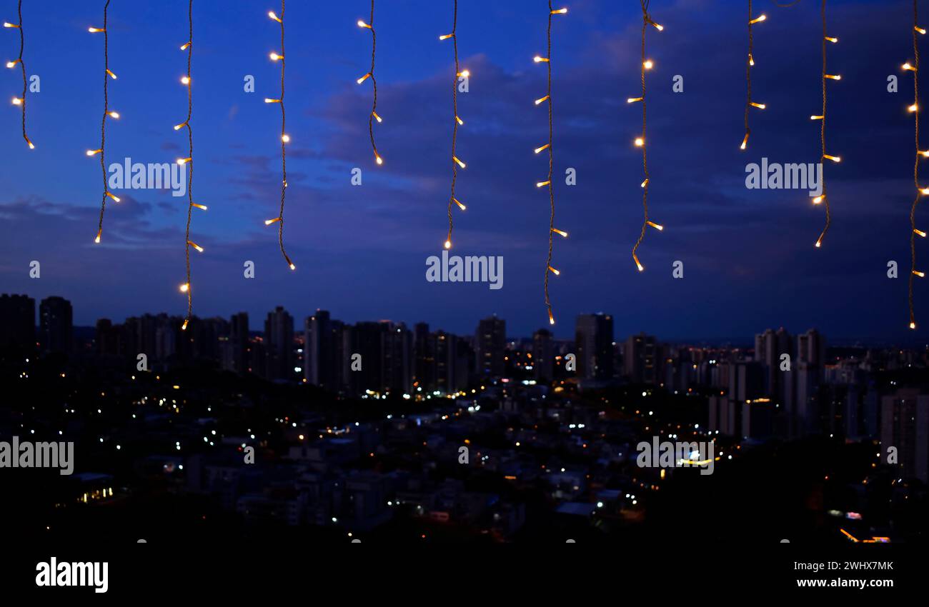 Weihnachtslichter und verschwommene Stadt im Hintergrund Stockfoto