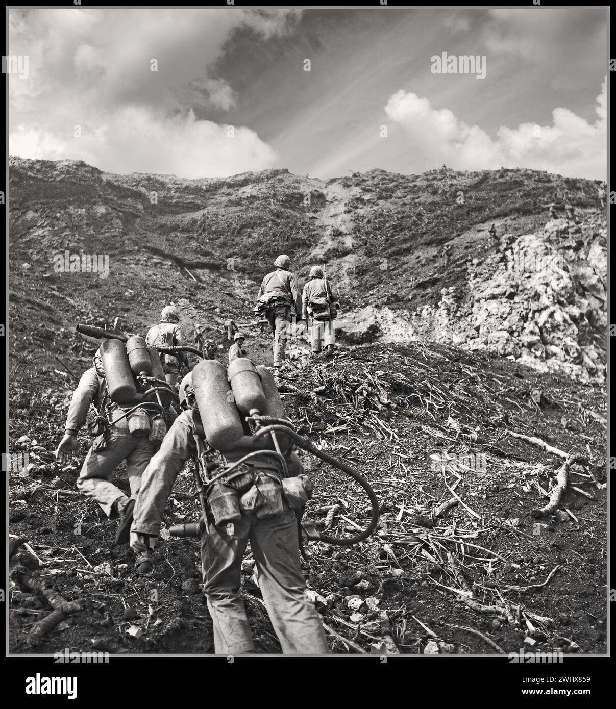 2. Weltkrieg Iwo Jima. Die amerikanischen Marines rücken im Vordergrund auf die Spitze der Suribachi Febr. 1945 Flammenwerfer vor, um die vielen japanischen Bunker und Fuchslöcher zu neutralisieren, die auf der ganzen Insel gebaut wurden. Die Schlacht von Iwo Jima war eine große Schlacht, in der das United States Marine Corps und die United States Navy während des Zweiten Weltkriegs die Insel Iwo Jima eroberten Zweiter Weltkrieg. Pazifikkrieg Stockfoto