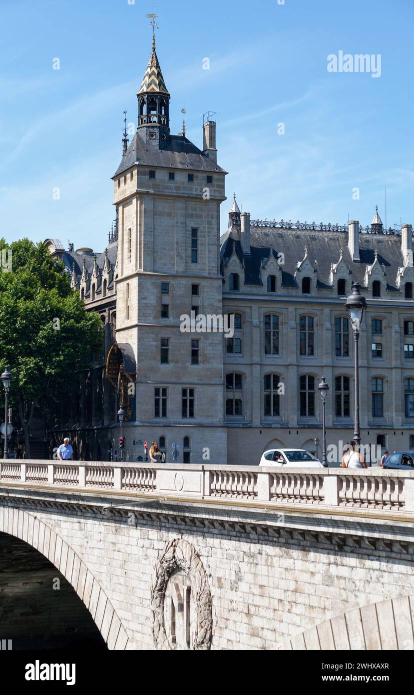 Paris, Frankreich - 07. Juli 2017: Menschen überqueren den Pont au Change mit hinter der Conciergerie, einem ehemaligen Gefängnis, das heute Teil des Palais de Justice ist. Stockfoto