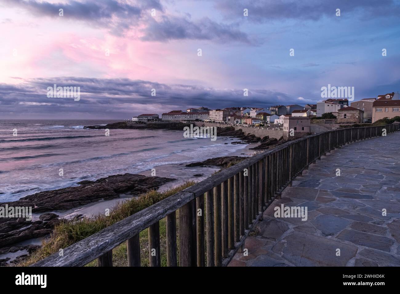 Die Strandpromenade verläuft entlang des Strandes Arnela bei Caión, einer galizischen Stadt, in der einst die Bewohner Walfang betrieben haben. Sonnenuntergangslicht. Stockfoto