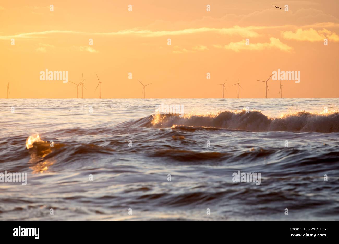 Meereswellen bei Susnet und Windmühlen Stockfoto