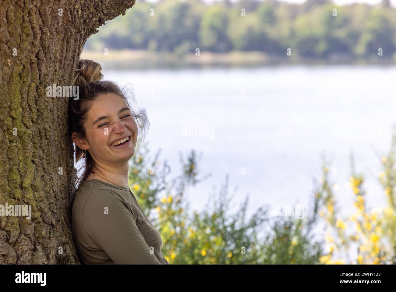 Gelassenheit inmitten der Natur: Ein lächelnder Millennial in Forest Escape Stockfoto