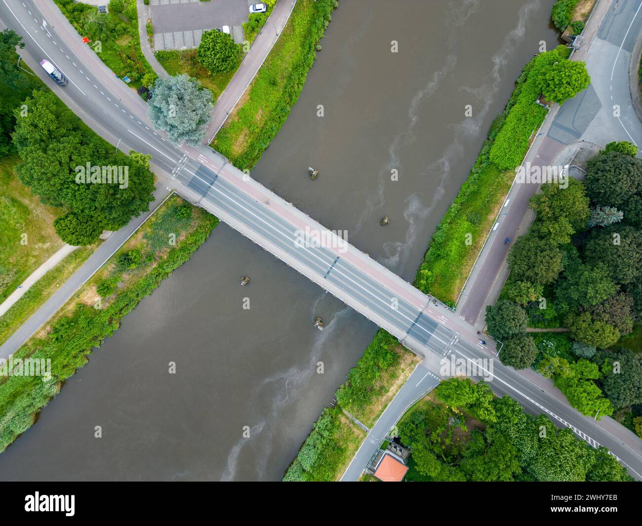 Aus der Vogelperspektive, pov direkt über der Brücke mit wenig Autoverkehr. Slow Aerial Birds Eye Overhead von oben nach unten Blick auf den tiefblauen Fluss oder Stockfoto