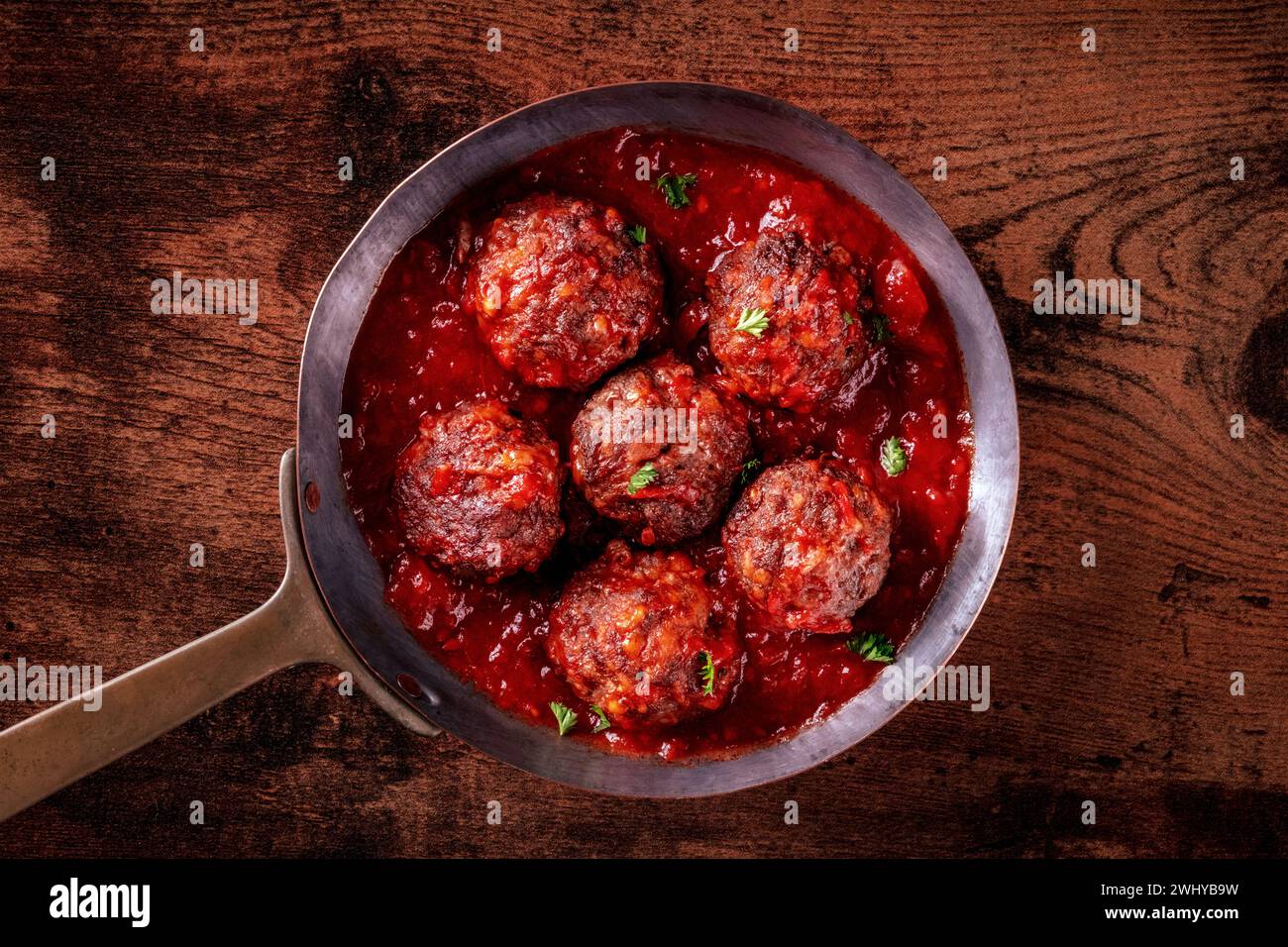 Fleischbällchen. Rindfleischbällchen, von oben in einer Pfanne geschossen, mit Tomatensauce Stockfoto