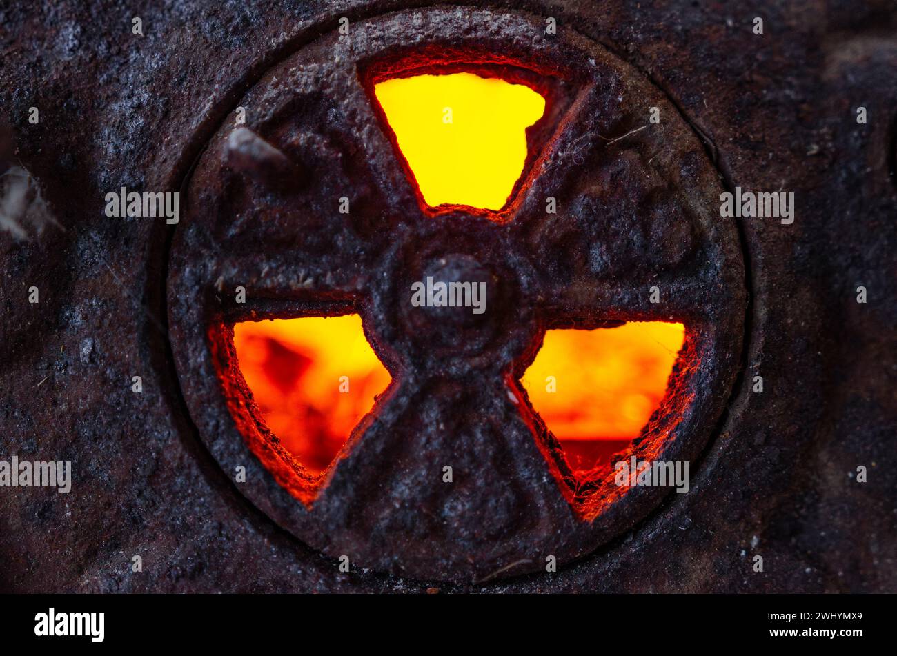 Radioaktives Symbol, Gusseisen, Hintergrundbeleuchtung, glühende Kohle, Flamme, Warnschild, Gefahr, nukleare Gefahr, Strahlungssymbol Stockfoto