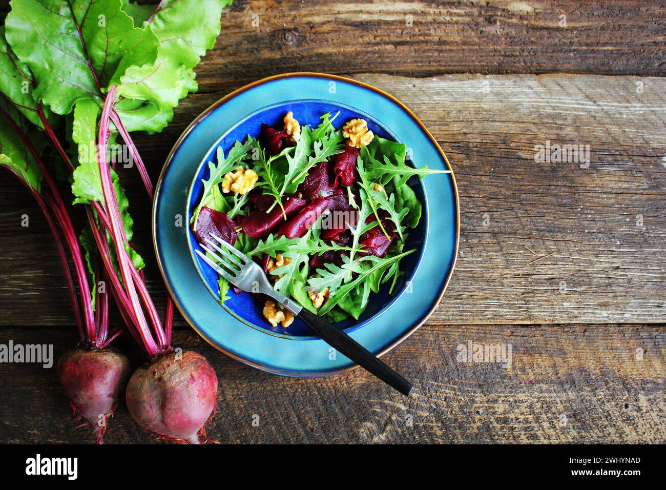 Gesunde Rüben Salat mit frischen süßen Baby Spinat, Rucola, Muttern auf Holz- Hintergrund. Ansicht von oben Stockfoto