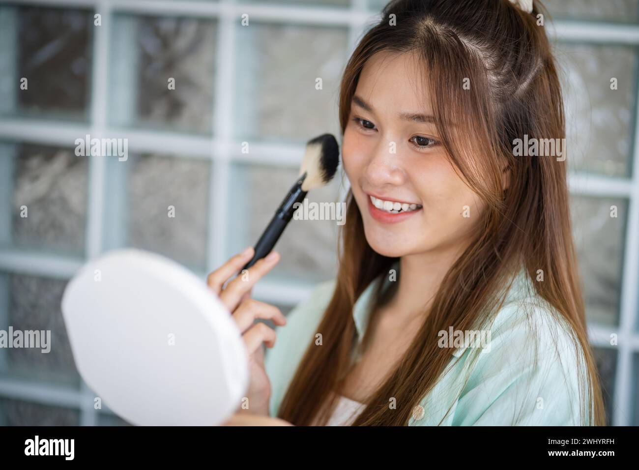 Beauty Influencer asiatische Mädchen Make-up Künstlerin, die Pudergrundierung mit Pinsel aufträgt. Beauty Influencer asian Girl Video Online Markt Stockfoto