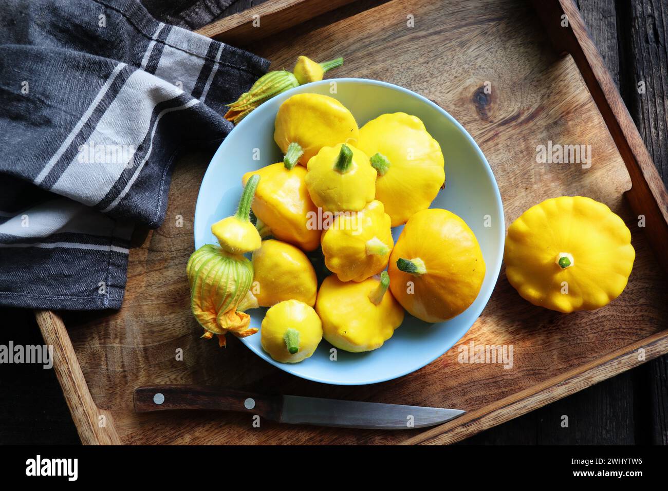 Gelber Patisson, pattypisches Jakobsmuschel-Kürbisgemüse auf blauer Platte auf weißem Marmortischhintergrund. Draufsicht, flach. Herbst, f Stockfoto