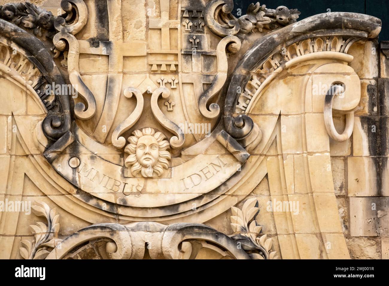 Lateinische Inschrift „omnibus idem“ an einer barocken Fassade in Valletta, Malta Stockfoto