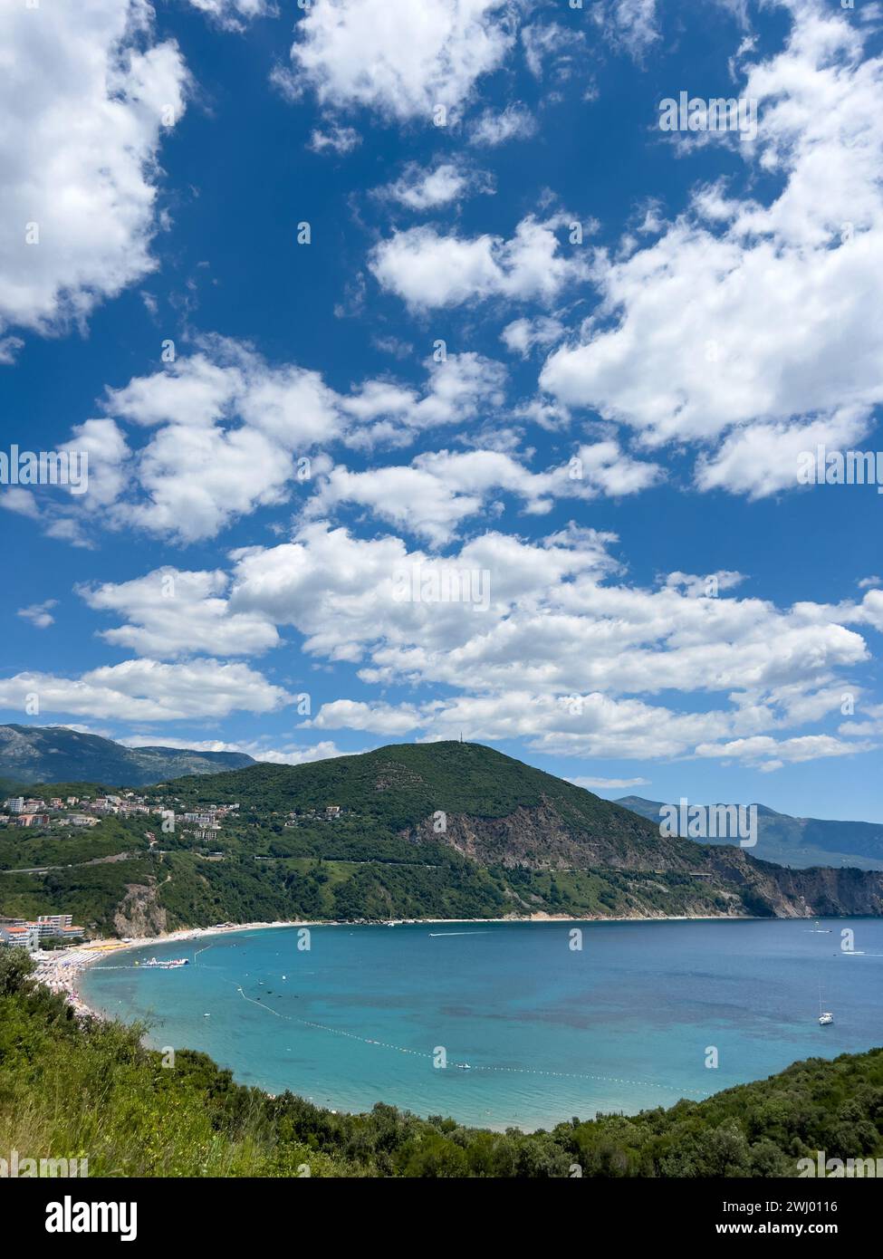 Yachten schweben in der Bucht, umgeben von einer hohen Bergkette vor einem bewölkten Himmel Stockfoto