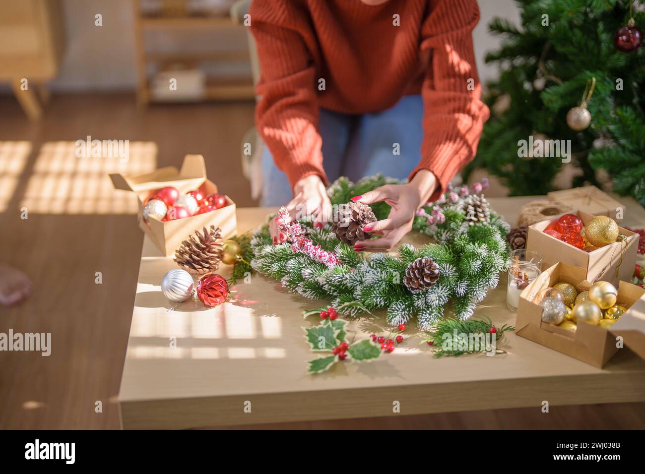 Frau, die Mistelkranz macht Weihnachtskranz Dekoration mit handgemachten DIY Winter Grün Blumenhändler Hände machen Weihnachtswrea Stockfoto