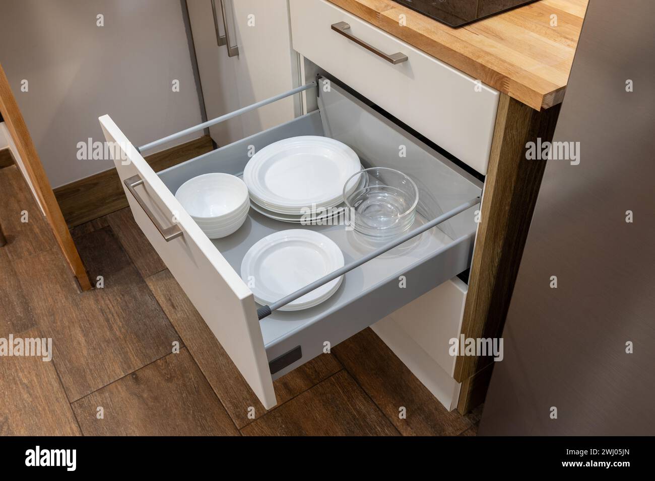Holzküche Schubladenorganizer, Utensilienhalter mit Geschirr, Teller, Kappen, Möbeldetails. Stockfoto
