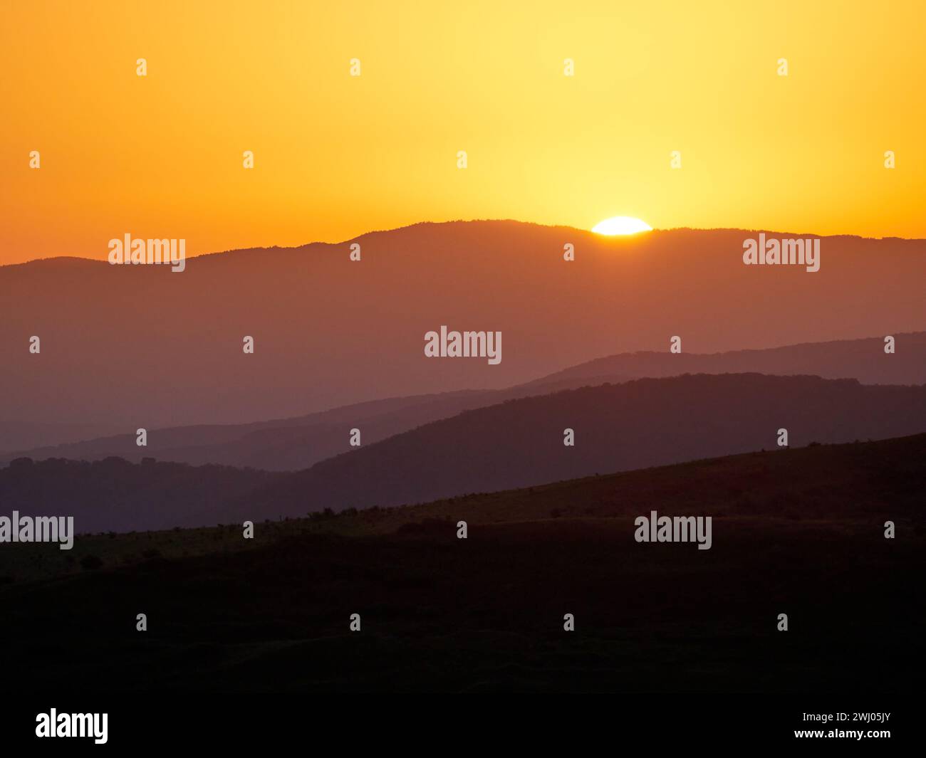 Erste Lichtstrahlen. Sonnenschein, neuer Tag. Sonnenaufgang in den Bergen. Dramatische Farben am nebeligen Morgen in den Bergen Stockfoto