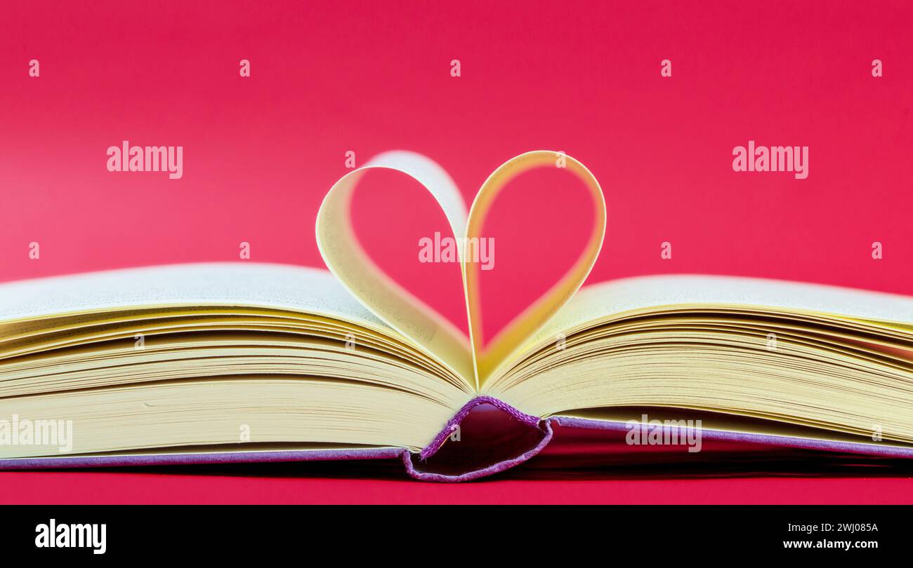 Buch in Herzform. Seiten eines Buches, die sich zu einer Herzform geformt haben. Geöffnetes Buch, Seiten in Herzform Stockfoto