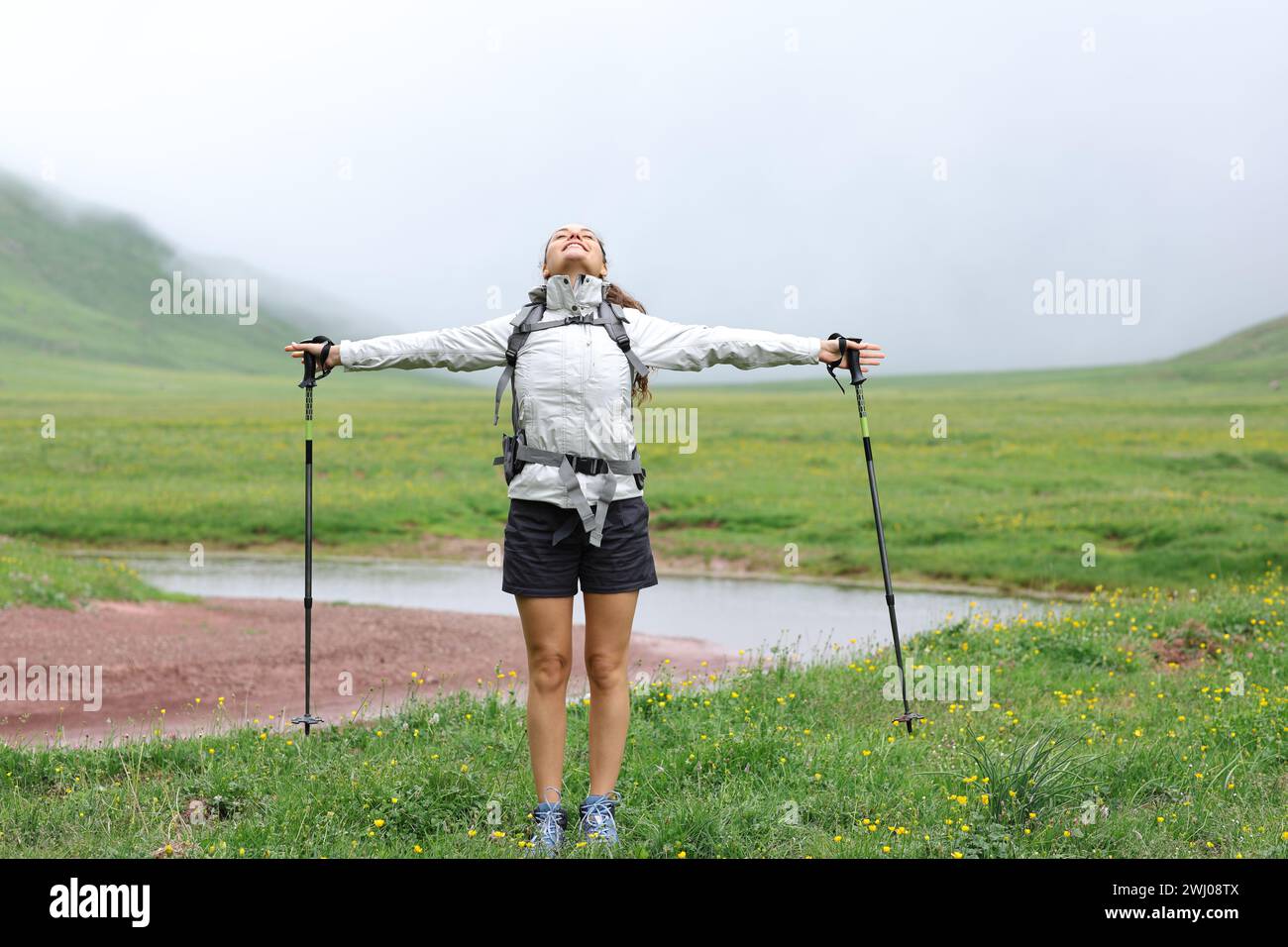 Wanderer feiert Urlaub Atem und Strecken Arme in einem Tal Stockfoto