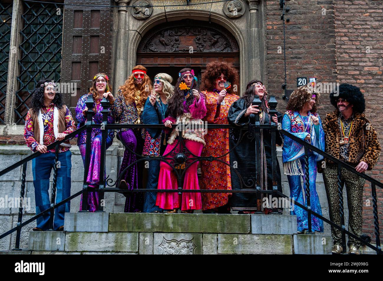 Nijmegen, Niederlande. Februar 2024. Der Bürgermeister der Stadt Hubert Bruls (oranges Kostüm) posiert während des Karnevals für die Fotos. In Nijmegen, Niederlande, besteht die Karnevalsparade aus einem Wagen, der von einem Elektrofahrzeug mit den Prinzen und Prinzessinnen des Jahres gezogen wird. Der Rest der Parade besteht aus Personen, die in bunten Kostümen und Musikbands gekleidet sind. Die Hauptattraktion jedes Jahr ist das Kostüm, das der Bürgermeister der Stadt Huber Bruls trägt, dieses Jahr war das Thema Flower Power. Quelle: SOPA Images Limited/Alamy Live News Stockfoto