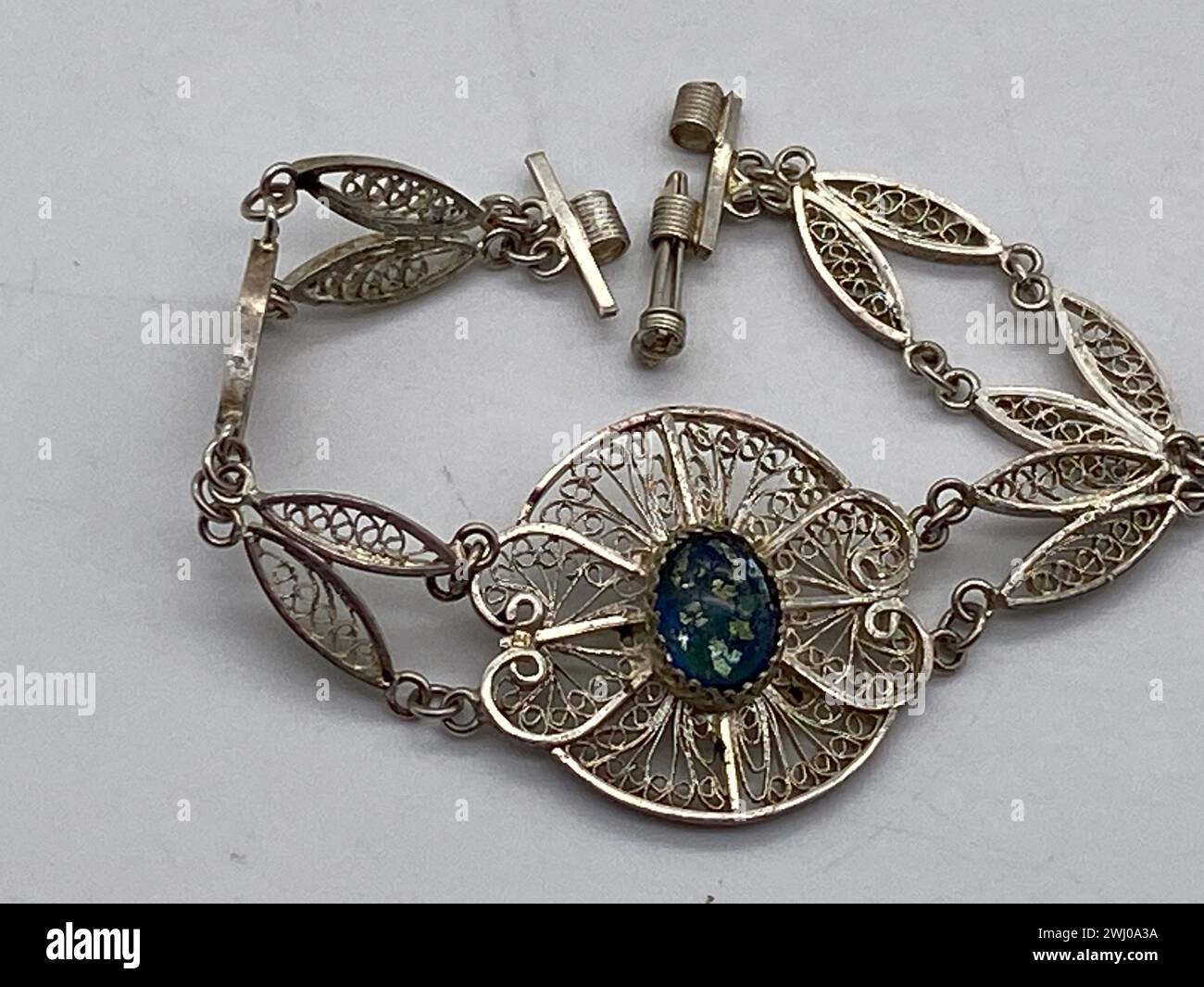 Armband mit zarten Blattmotiven und einem faszinierenden Opalitstein-Herzstück Stockfoto