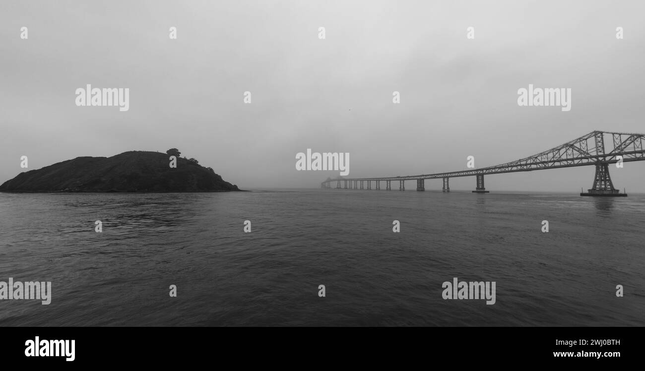 Ein Schwarz-weiß einer Brücke vor einem bewölkten Himmel Stockfoto