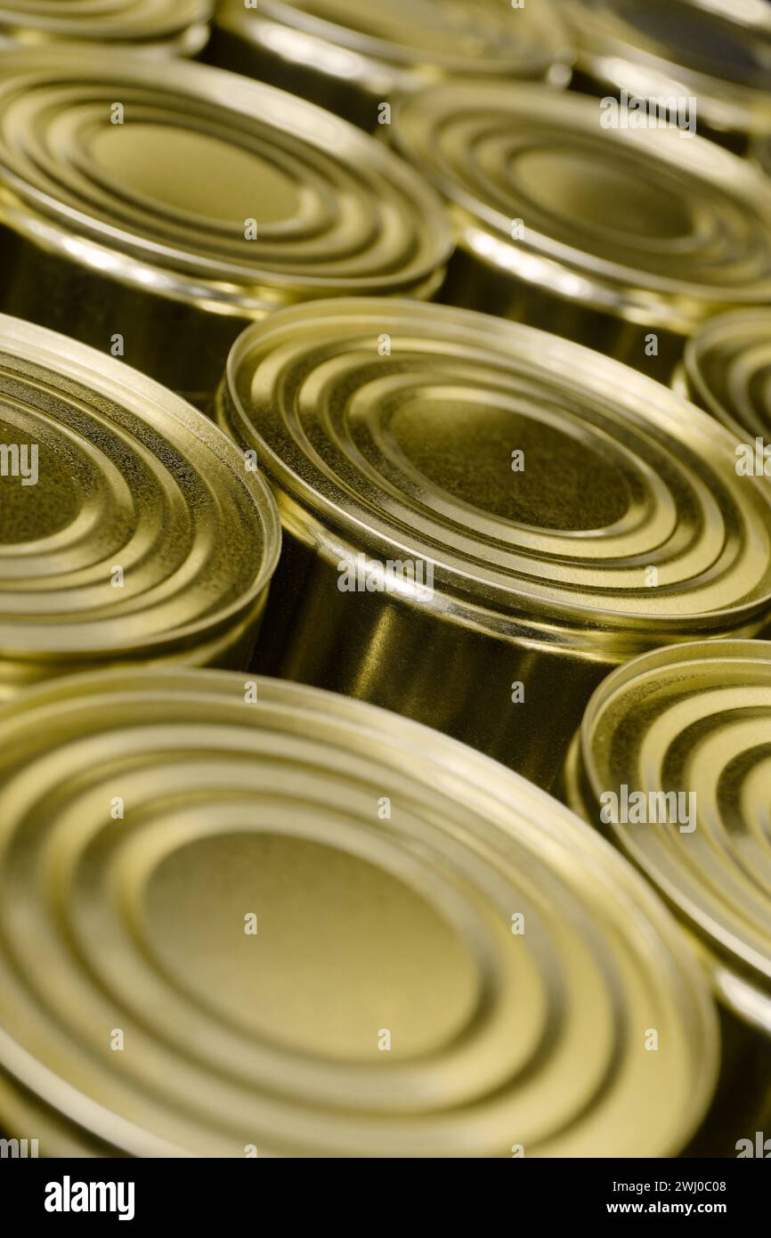 Große Gruppe von leeren, unbeschrifteten runden Blechdosen, abstrakter Hintergrund der Lebensmittelindustrie Stockfoto