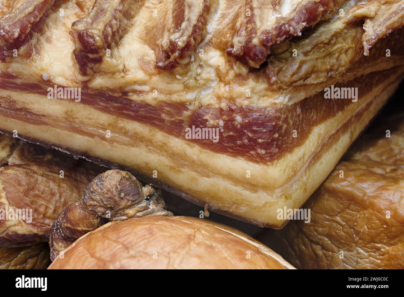 Gemischtes geräuchertes Fleisch auf einer Markttheke, abstrakter Essenshintergrund Stockfoto