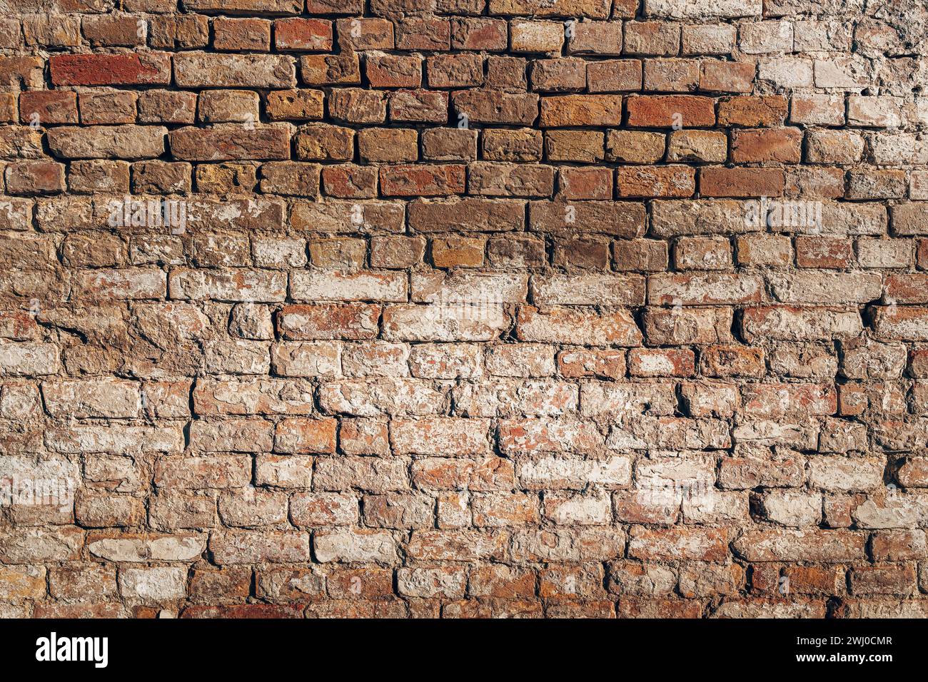 Textur einer alten beschädigten Mauermauer, Backsteinmaueroberfläche als Hintergrund, alte Hausruine Stockfoto