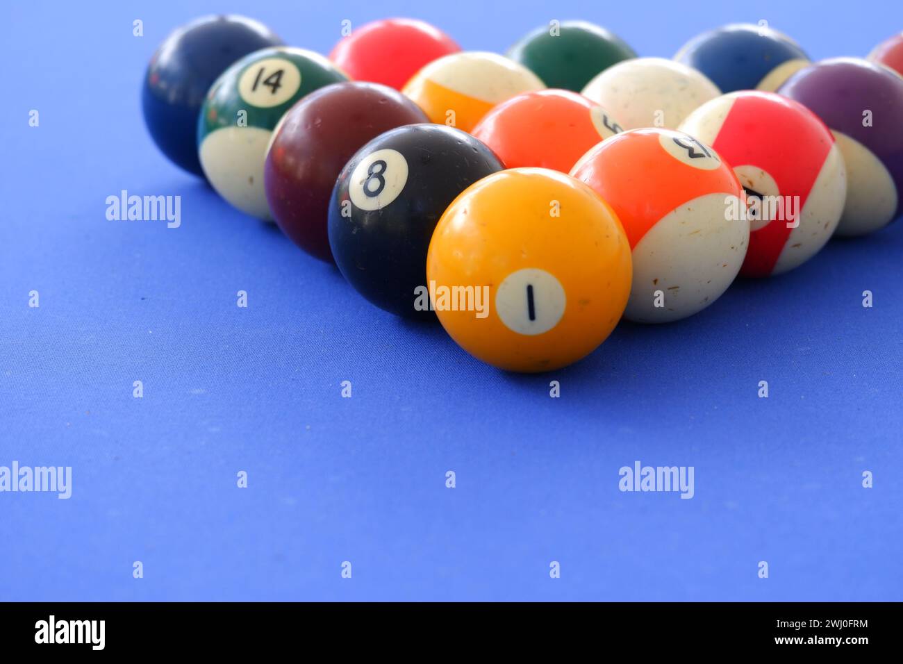 Billard-Kugeln und Billard-Queue sind an einem sonnigen Sommertag im Freien auf dem blauen Billard-Tisch. Kugeln in Dreiecksform Stockfoto