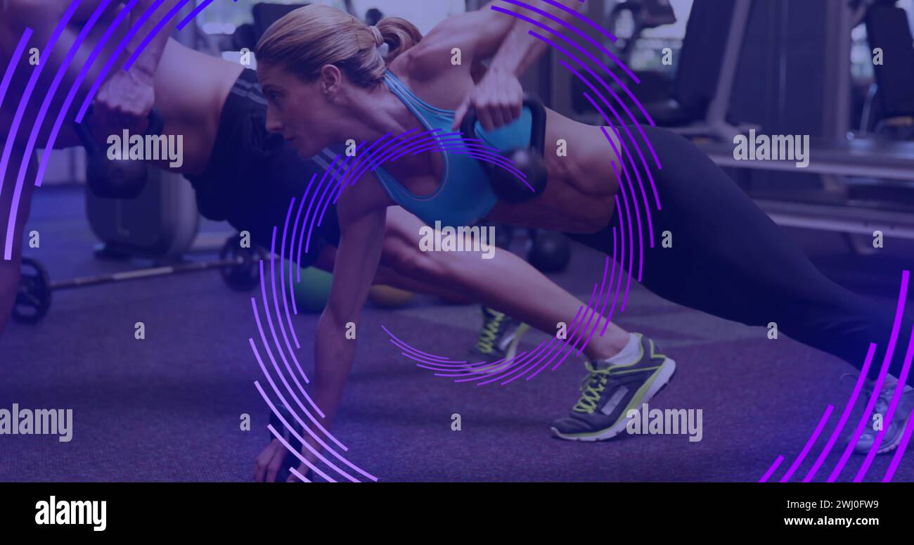 Fitness-Enthusiasten führen ein Partner-Workout im Fitnessstudio durch Stockfoto