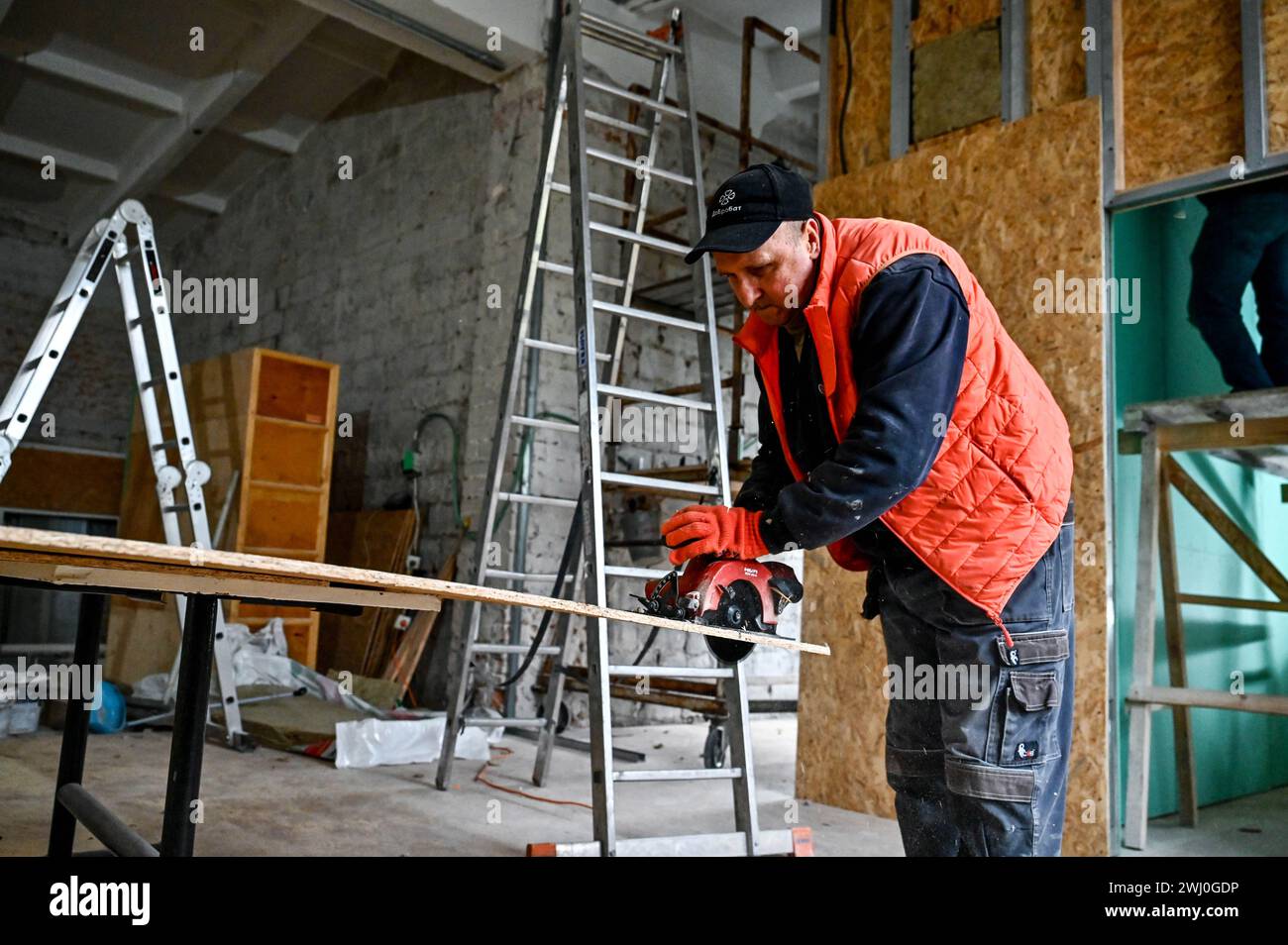 ZAPORIZHZHIA, UKRAINE - 9. FEBRUAR 2024 - Freiwillige der NRO Dobrobat, ein freiwilliges Baubataillon, das den Überlebenden in den entbesetzten Gebieten bei der dringenden Wiederherstellung von Wohnraum und sozialer Infrastruktur hilft, reparieren die Nationalen Akademie Chortytsia, die durch den russischen Beschuss beschädigt wurde, Zaporischschschhia, Südostukraine. Stockfoto