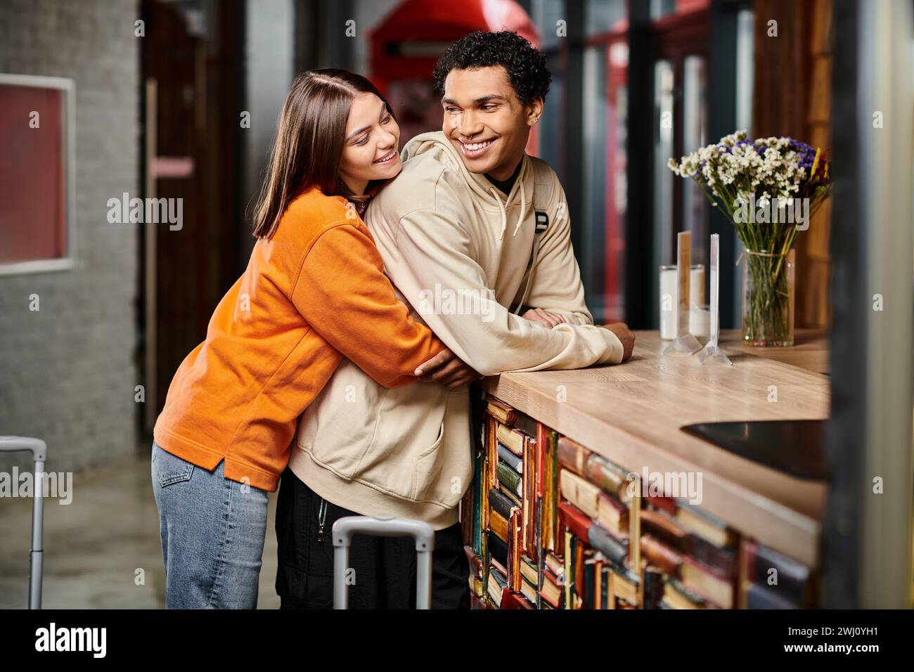 Ein romantischer Moment, der zwischen Mann und Frau geteilt wird, während sie sich an der Rezeption im Hostel umarmen Stockfoto
