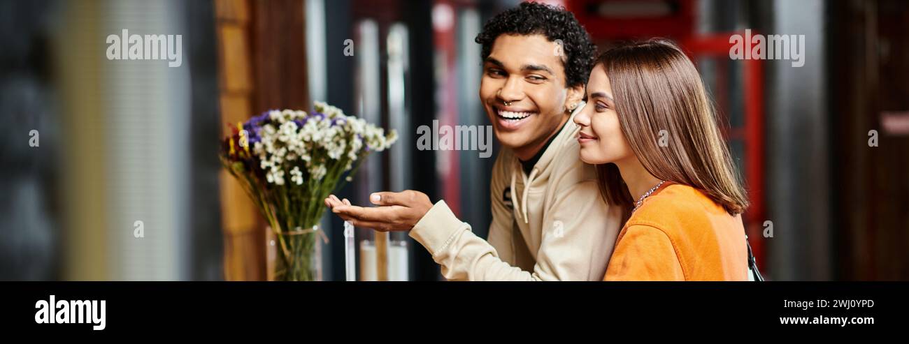 Glückliche junge Frau lächelt neben ihrem schwarzen Freund an der Rezeption des Hostels während des Eincheckens, Banner Stockfoto