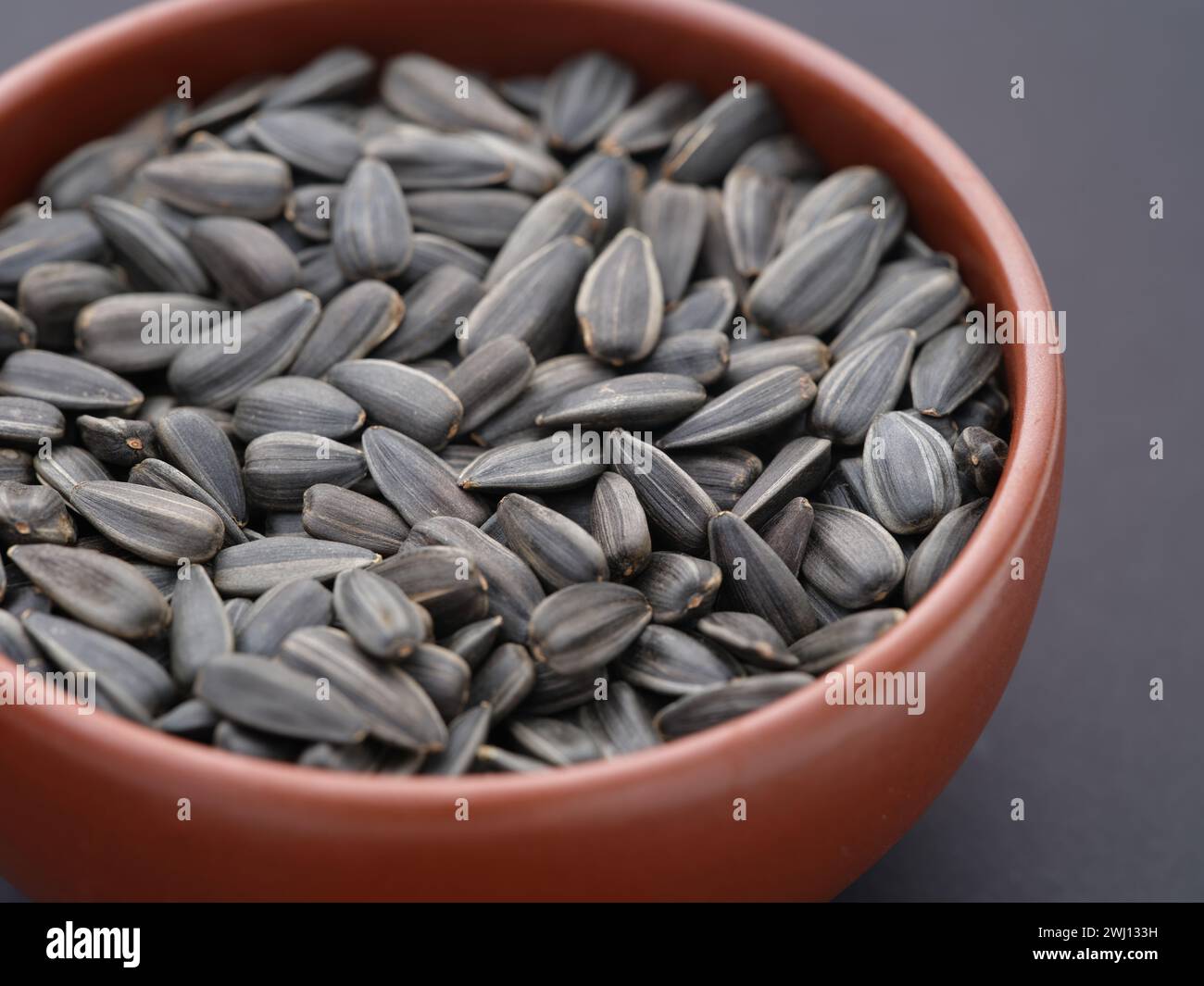 Sonnenblumenkerne in einer Schüssel auf schwarzem Hintergrund. Nahaufnahme. Stockfoto