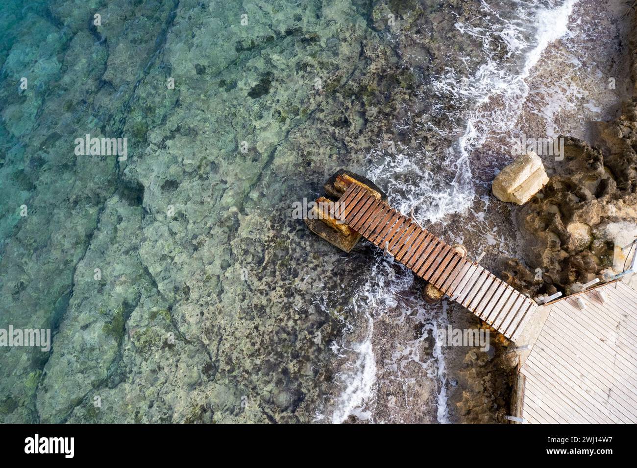 Drohnenblick von oben auf einen verlassenen Pier im Meer. Verkehrsinfrastruktur Stockfoto
