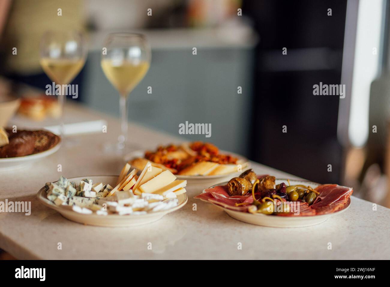 Zwei Gläser kühlen Champagner und Teller mit verschiedenen Snacks auf einem Tisch Stockfoto