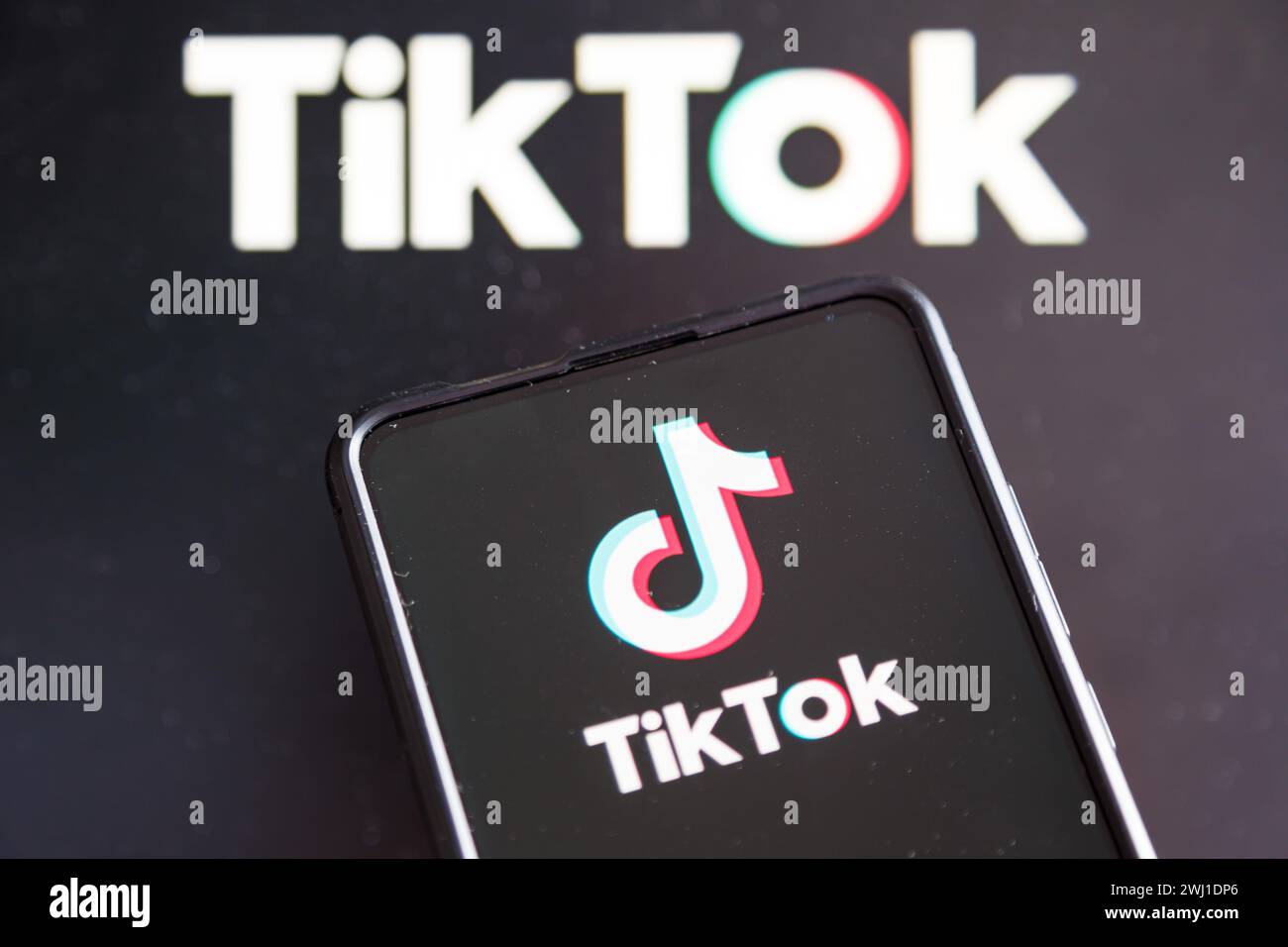 TikTok-Logo in sozialen Medien auf einem Mobiltelefon und einem Computerbildschirm Stockfoto