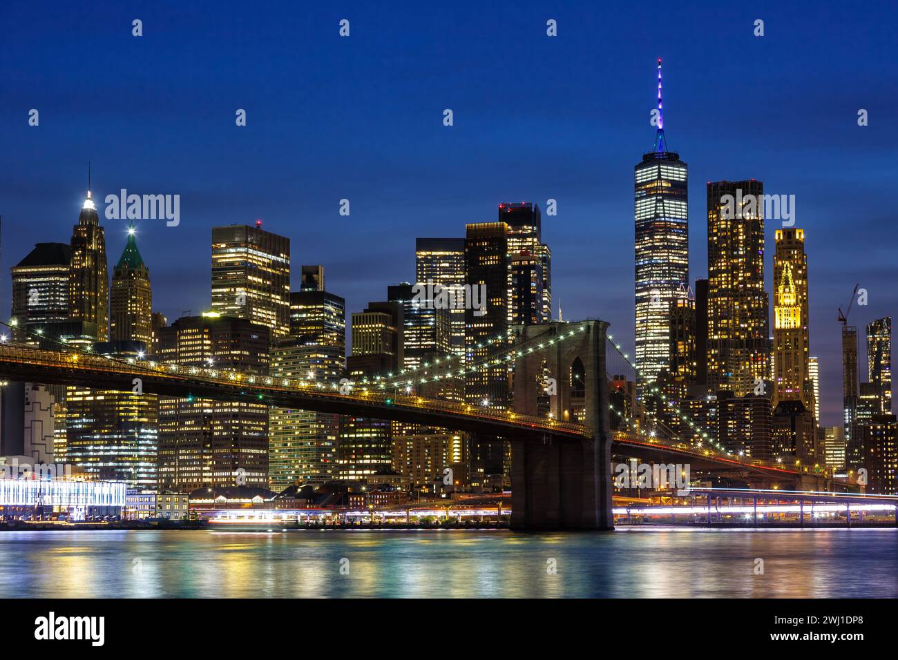 New York City Skyline von Manhattan mit Brooklyn Bridge und World Trade Center Wolkenkratzer bei Nacht in den USA Stockfoto