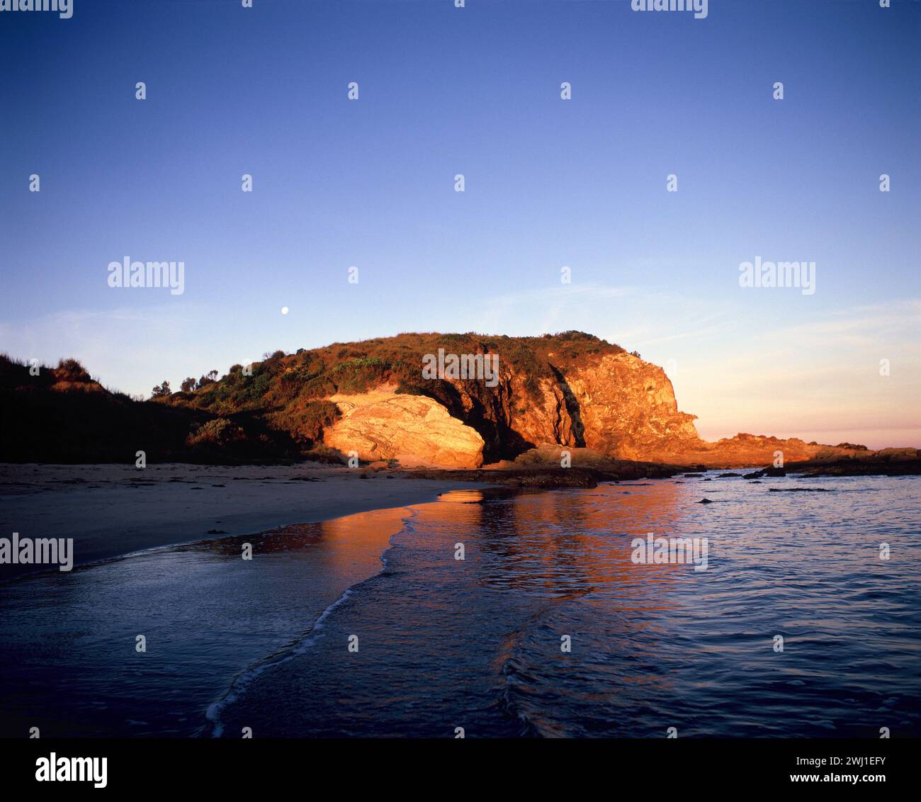 Australien. New South Wales. Südküstenregion. Blick auf die Landzunge von Tomakin Bay bei Sonnenuntergang. Stockfoto