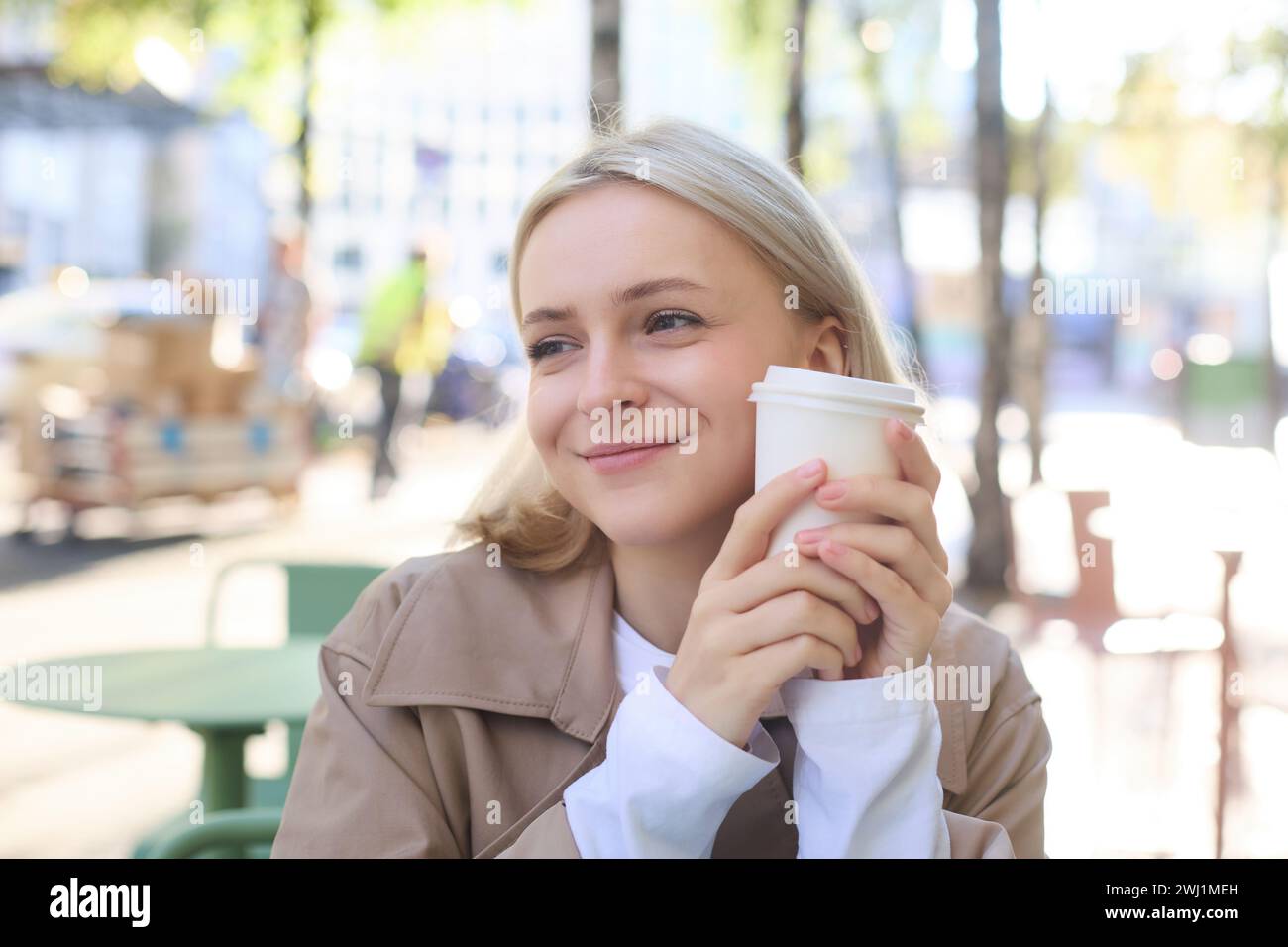 Nahaufnahme Porträt einer lächelnden, glücklichen, schönen Europäerin, die im Café sitzt und eine Tasse Kaffee genießt, ein Getränk trinkt, Enj Stockfoto