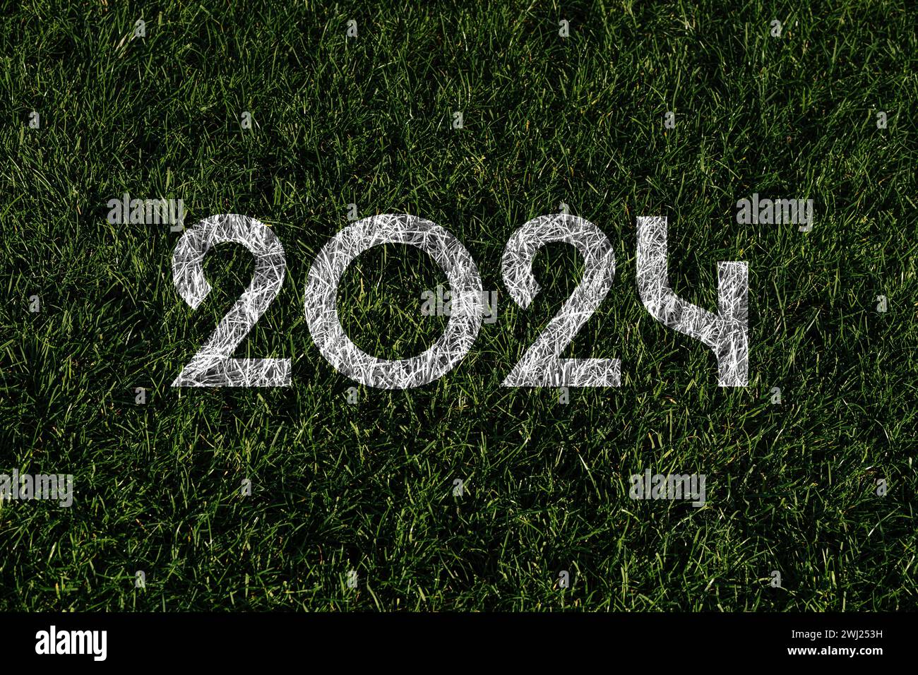 „2024“ in weiß auf grünem Gras des Fußballfeldes, symbolisiert Sommersportspiele Stockfoto