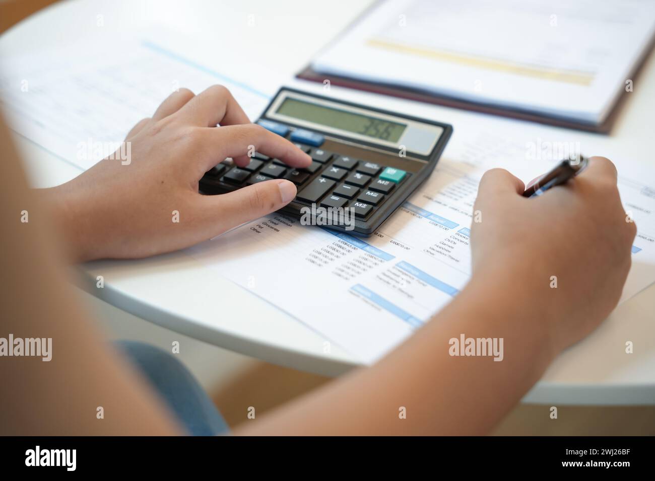 Geschäftsfrau Buchhalter Analyse von Investitionstabellen Rechnung und Drücken von Rechnerschaltflächen über Dokumenten. Buchhaltung Stockfoto