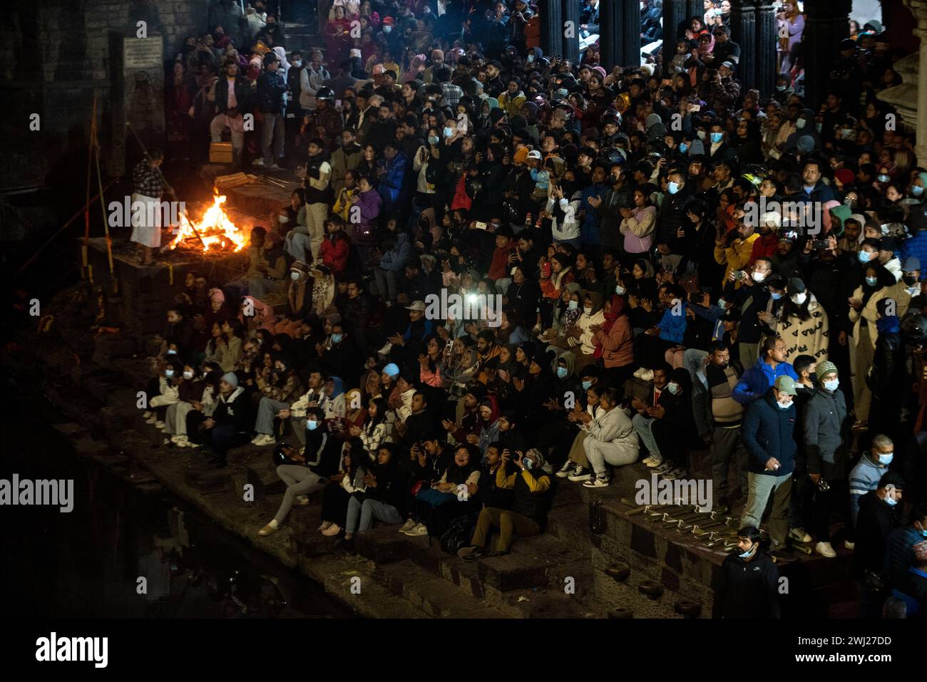 Hinduistische Gläubige versammeln sich im Pashupatinath Tempel am Ufer des heiligen Krematoriums am Bagmati River, um am Montag, dem Tag des Herrn Shiva, Kathmandu, Nepal, am Montag, den 12. Februar 2024 das Abendgebet zu hören Stockfoto