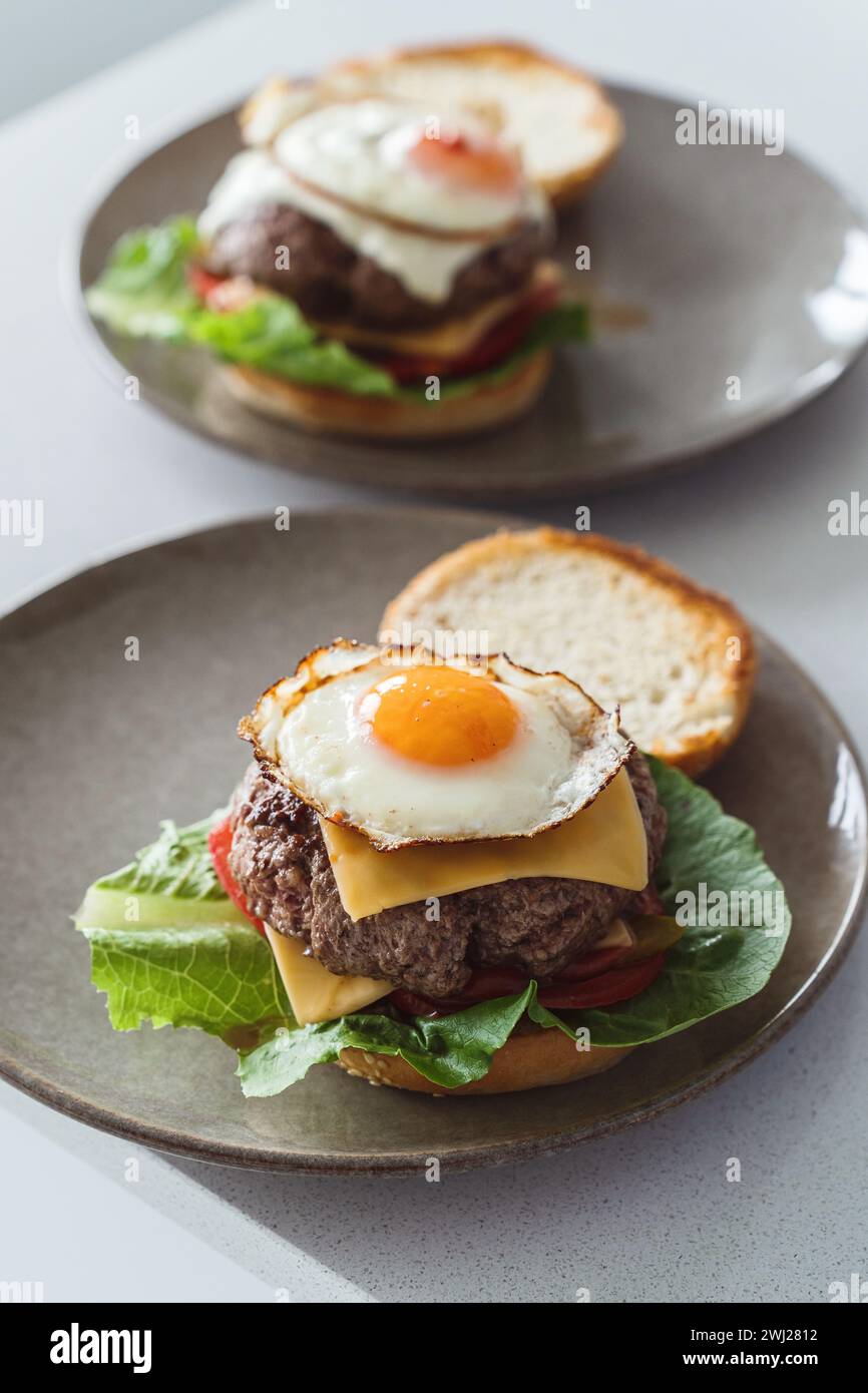 Köstlicher hausgemachter Cheeseburger garniert mit einem perfekt gebratenen, sonnigen Ei Stockfoto