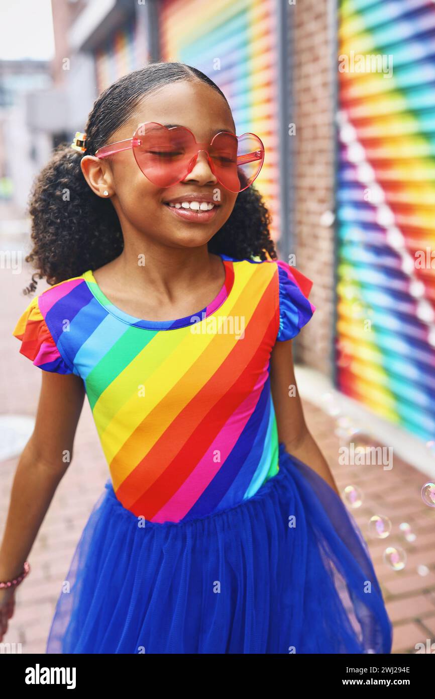 Ein junges Mädchen lächelt mit Blasen vor einem Wandbild in Washington, DC Stockfoto