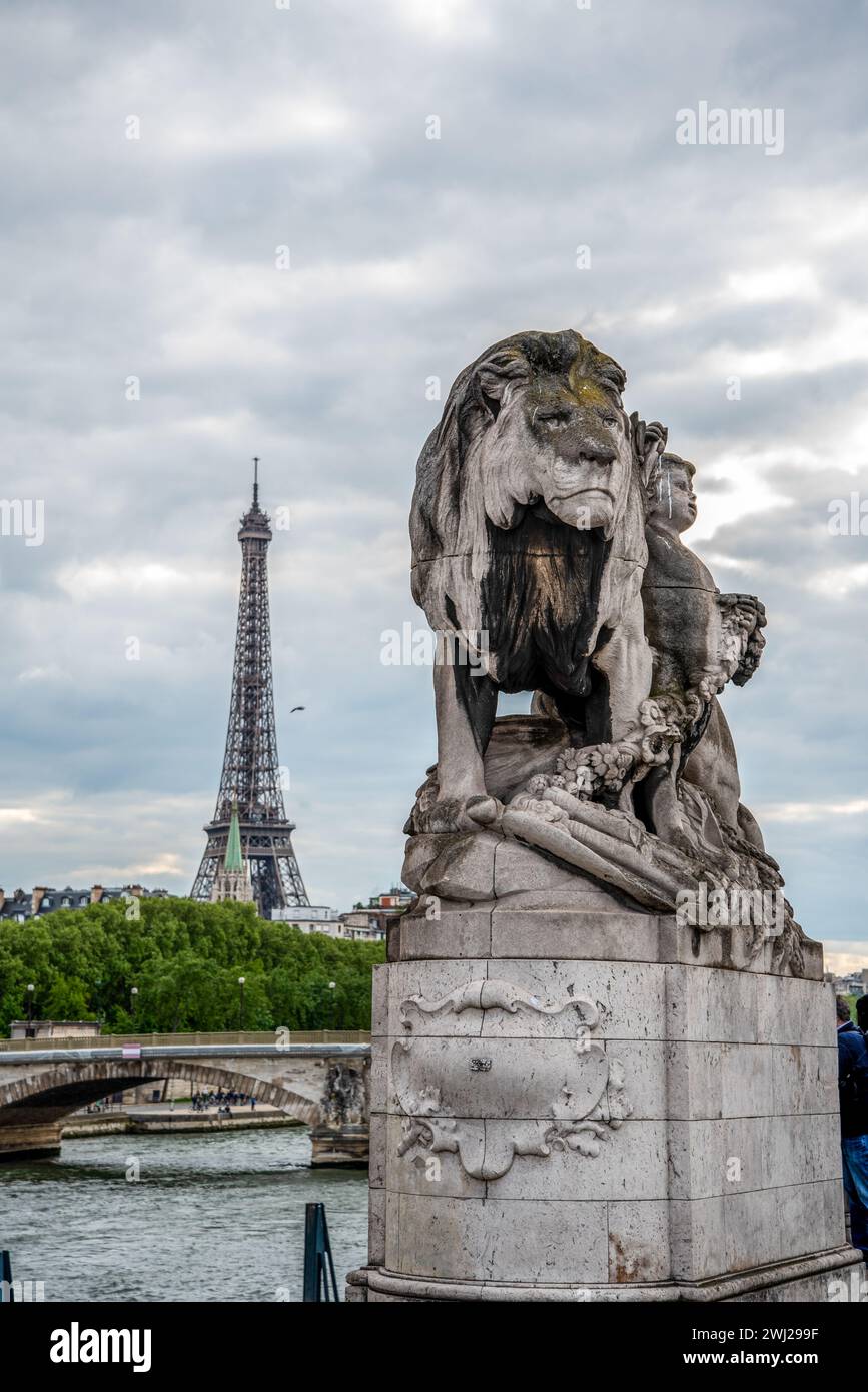 Statue eines Lioins auf der Brücke Alexandre III, Blick auf den Eiffelturm, Paris Stockfoto